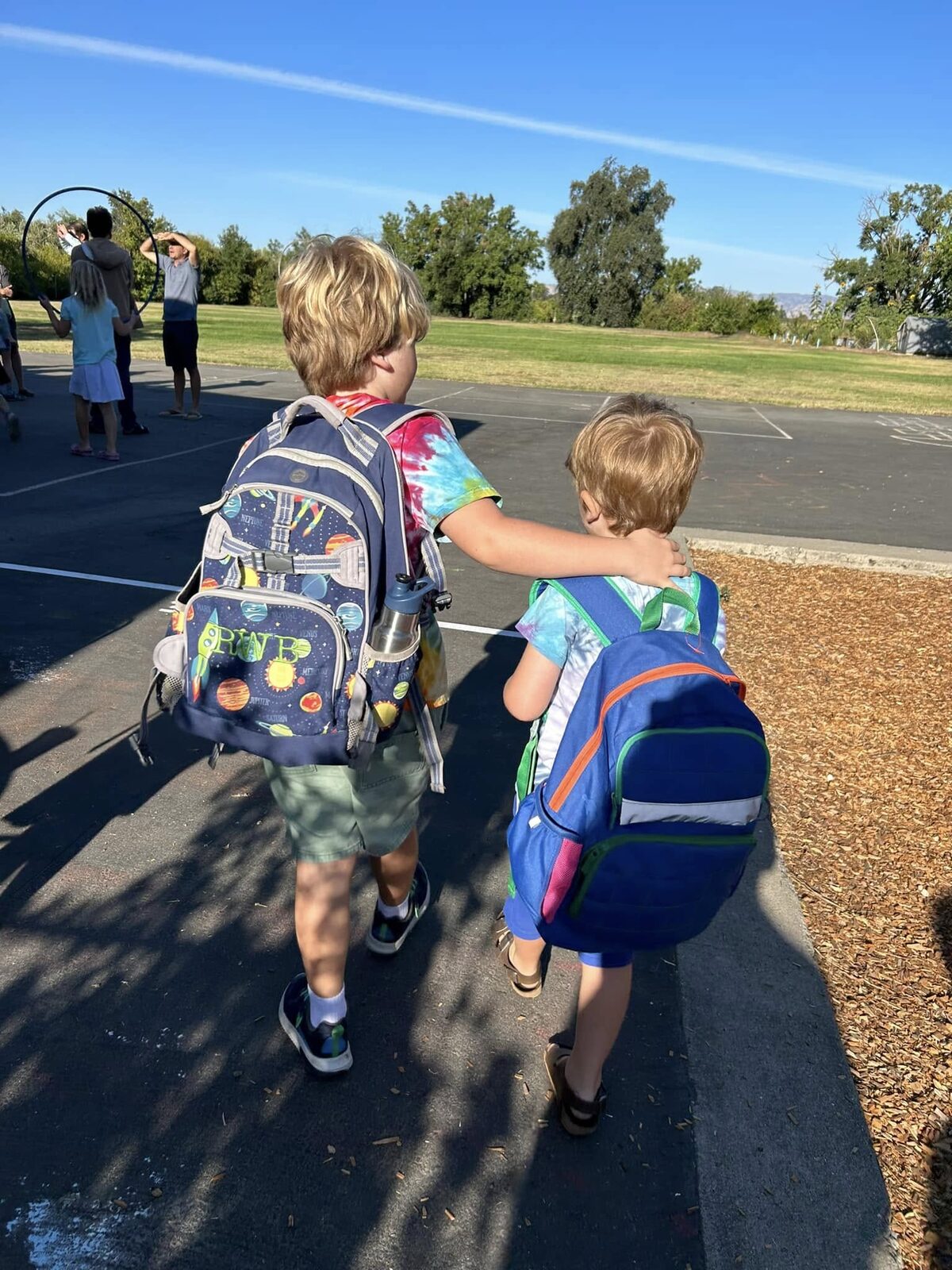 Judy's two boys walking to school with backpacks