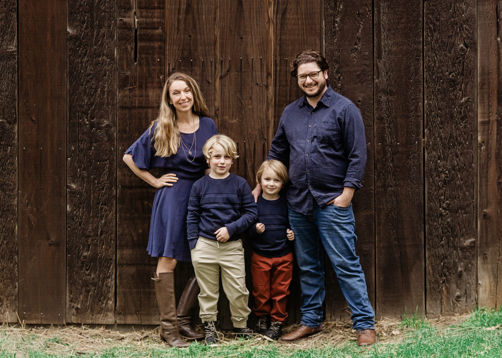 Judy with her husband and two boys in front of a barn