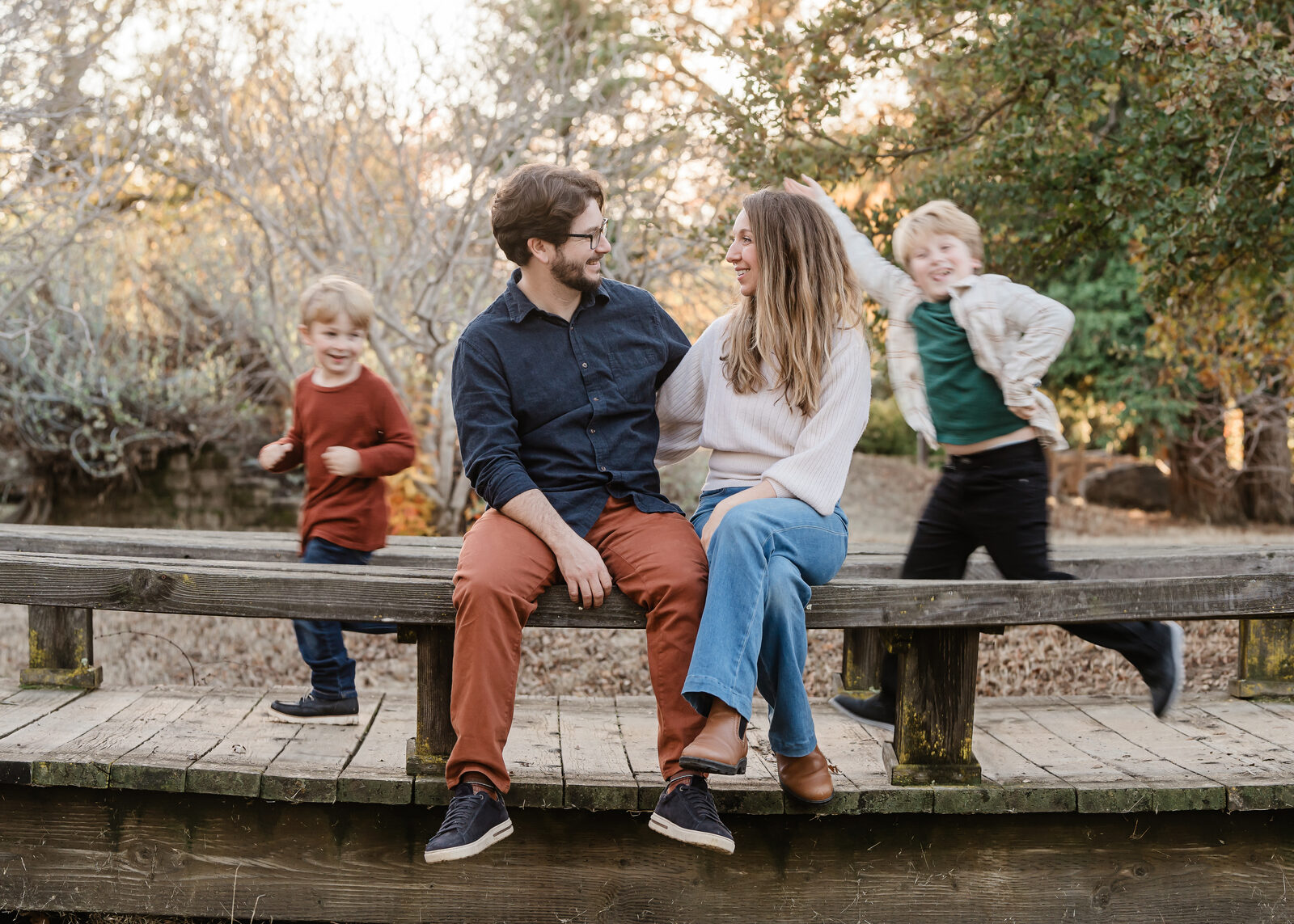 Judy and her husband on a bridge while their boys run by