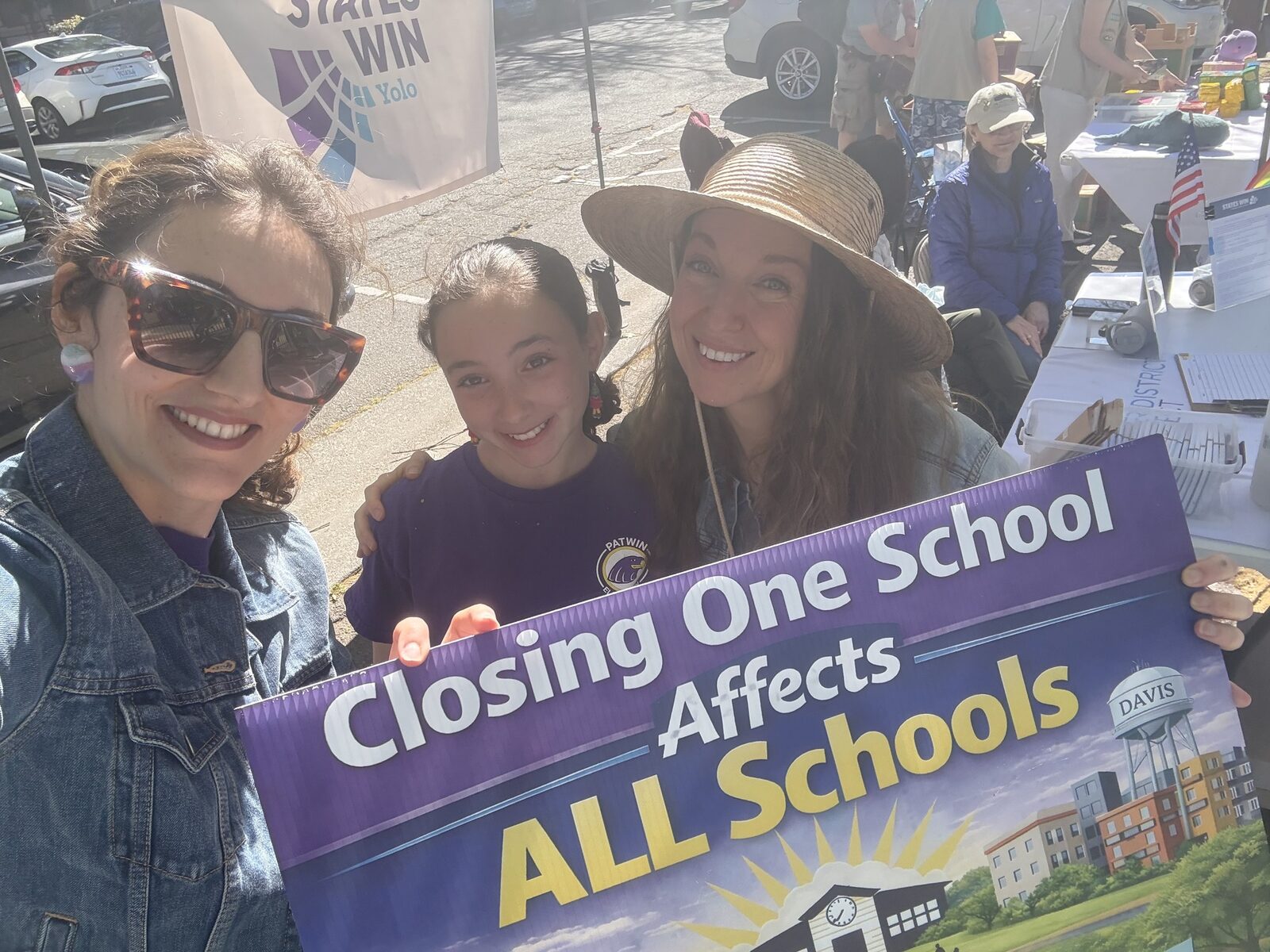 Judy at a Davis schools rally holding a sign about school closures